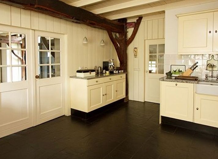 Charmantes Ferienhaus Hoeve den Anholt in Ruinen, Drenthe, mit traditioneller Backsteinfassade und gruener Umgebung.