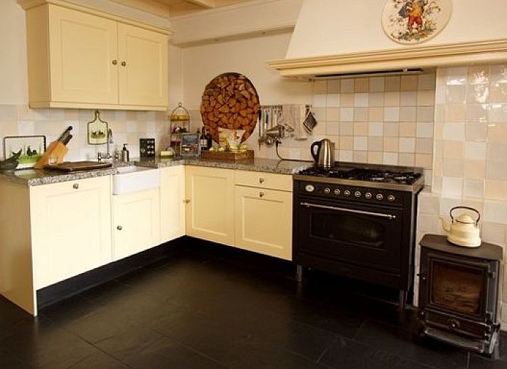 Charmantes Ferienhaus Hoeve den Anholt in Ruinen, Drenthe, mit traditioneller Backsteinfassade und gruener Umgebung.