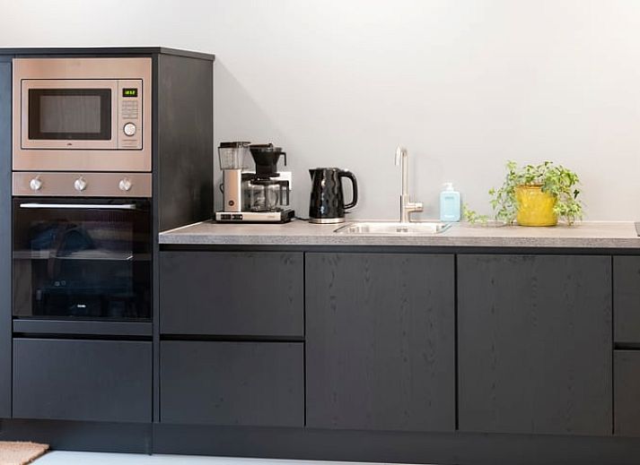 Gezellige woonkamer in Vakantiehuisje in Dwingeloo, Drenthe, met uitzicht op de natuurrijke omgeving.