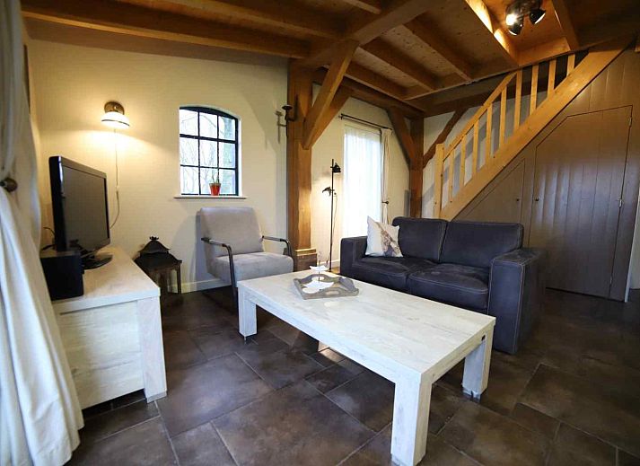 Cozy living room in DG591 vacation home, Dwingeloo, Drenthe, with comfortable seating and garden views.