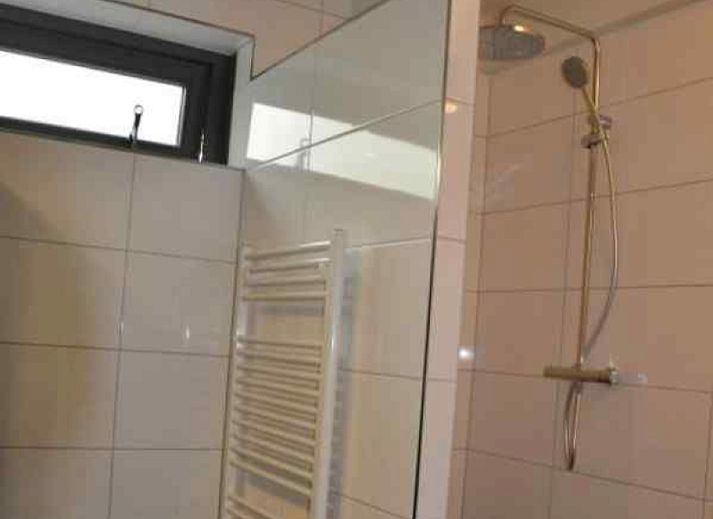 Moderne Kueche des Ferienhauses DG567 in Dwingeloo, Drenthe mit Essecke und grossen Fenstern.