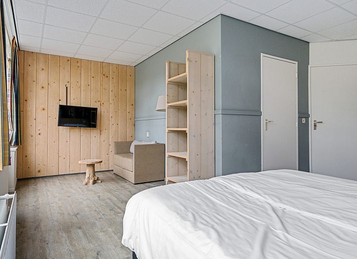 Ruime binnenruimte van Groepsaccommodatie de Komeet in Dwingeloo, Drenthe, met grote tafels en uitzicht op de groene omgeving.