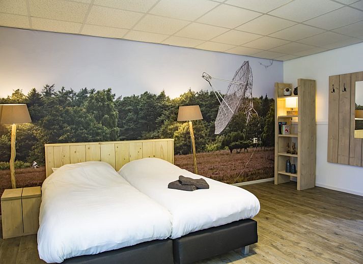 Ruime binnenruimte van Groepsaccommodatie de Komeet in Dwingeloo, Drenthe, met grote tafels en uitzicht op de groene omgeving.