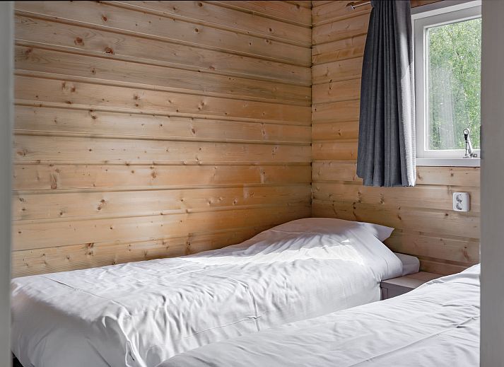 Cozy living room of Hooiberglodge in Dwingeloo, Southwest Drenthe. Enjoy a cozy vacation home with wooden interior and comfortable seating area.