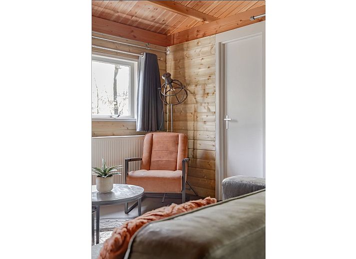 Cozy living room of Hooiberglodge in Dwingeloo, Southwest Drenthe. Enjoy a cozy vacation home with wooden interior and comfortable seating area.