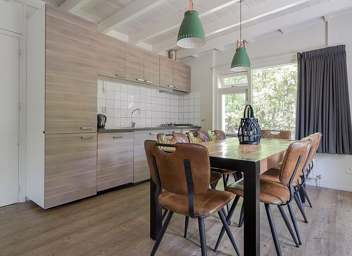 Gezellige woonkamer van Bungalow Maan in Dwingeloo, Zuidwest Drenthe. Comfortabele zithoek met uitzicht op de groene natuur.