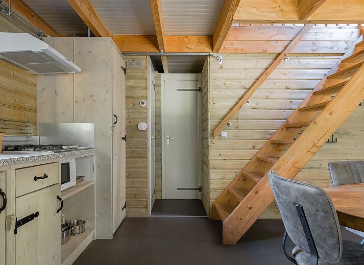 Cozy interior of Heidelodge vacation home in Dwingeloo, Southwest Drenthe, with wooden interior and modern kitchen.