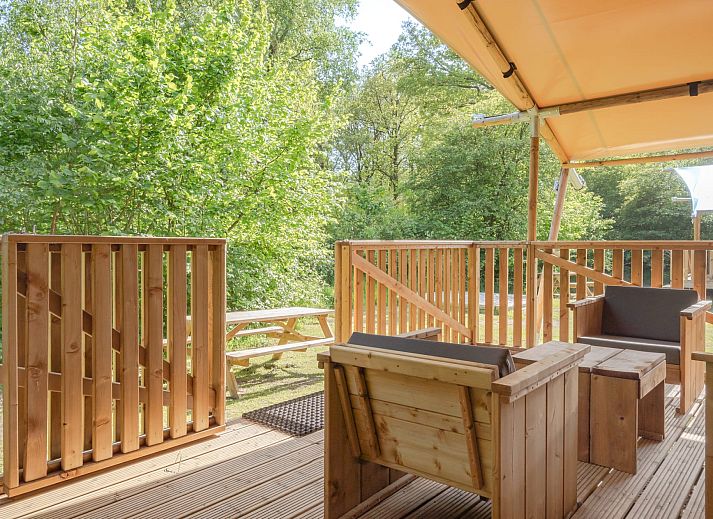 Das Safarizelt Castor in Dwingeloo, Drenthe, bietet eine charmante Glamping-Lodge mit einer einladenden Veranda mitten im Gruenen.