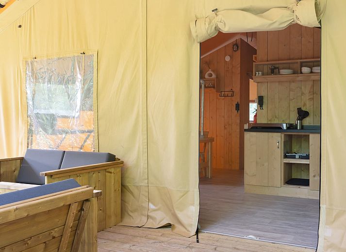 Das Safarizelt Castor in Dwingeloo, Drenthe, bietet eine charmante Glamping-Lodge mit einer einladenden Veranda mitten im Gruenen.