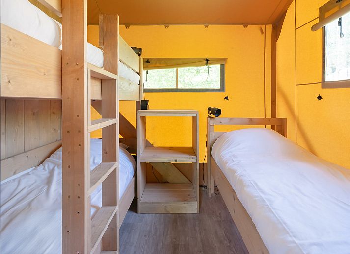 Gezellige binnenruimte van Safaritent Ceres, een vakantiehuis in Dwingeloo, Zuidwest Drenthe, met houten meubels.