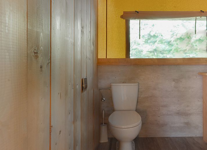 Gezellige binnenruimte van Safaritent Ceres, een vakantiehuis in Dwingeloo, Zuidwest Drenthe, met houten meubels.