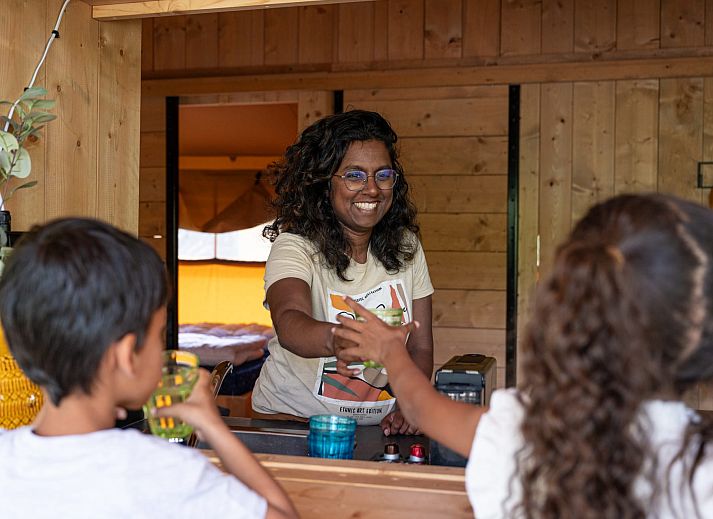 Gezellige binnenruimte van Safaritent Ceres, een vakantiehuis in Dwingeloo, Zuidwest Drenthe, met houten meubels.