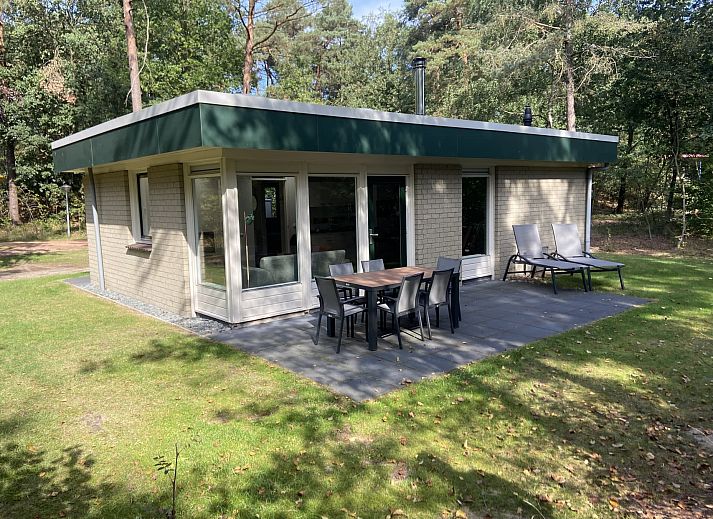 Gezellige woonkamer van Bungalow Mercurius in Dwingeloo, Zuidwest Drenthe, met uitzicht op het bosrijke terras.