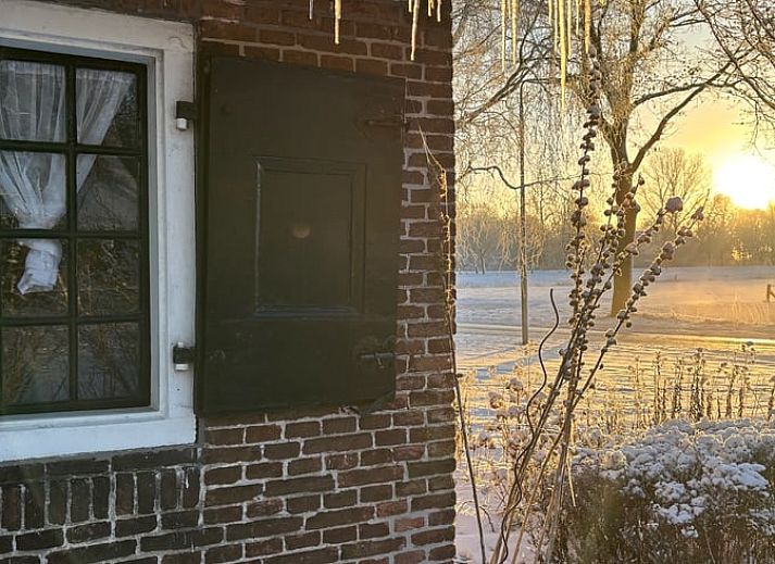 Gemuetliche Einrichtung des Ferienhauses in Ruinerwold, Drenthe, mit authentischem Kamin und gemuetlichem Bettgestell fuer einen stimmungsvollen Aufenthalt.