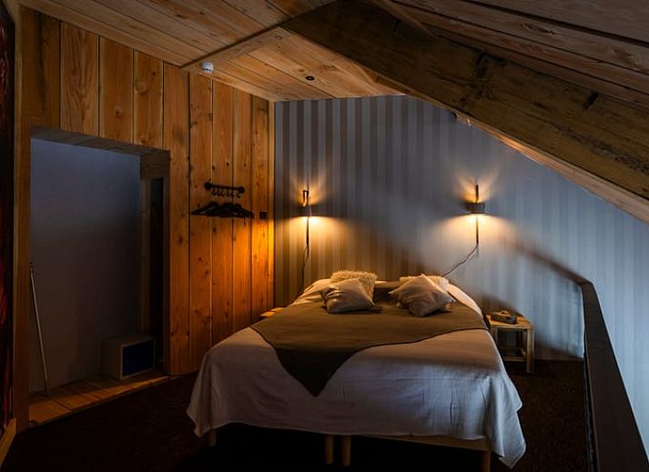 Gezellige woonkamer in vakantiehuis Ruinerwold, Drenthe met comfortabele zithoek en houten elementen.