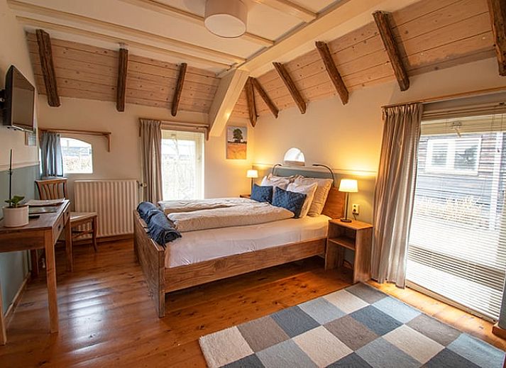 Gemuetliches Esszimmer im Ferienhaus in Ruinerwold, Suedwest-Drenthe, mit Holztisch und warmer Atmosphaere, ideal fuer Familienurlaub.