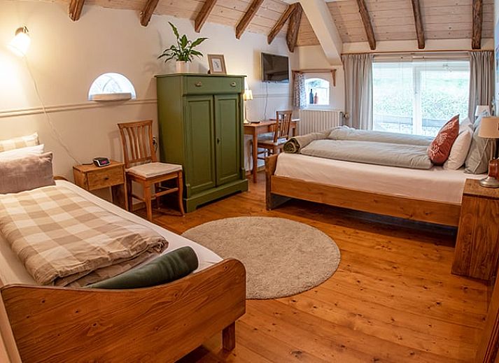 Gemuetliches Esszimmer im Ferienhaus in Ruinerwold, Suedwest-Drenthe, mit Holzmoebeln und warmer Atmosphaere fuer einen entspannten Aufenthalt.