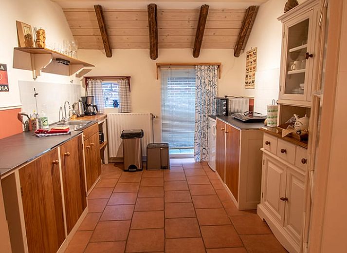 Gemuetliche Essecke im Ferienhaus in Ruinerwold, Suedwest-Drenthe, mit Holzmoebeln und stimmungsvoller Beleuchtung.