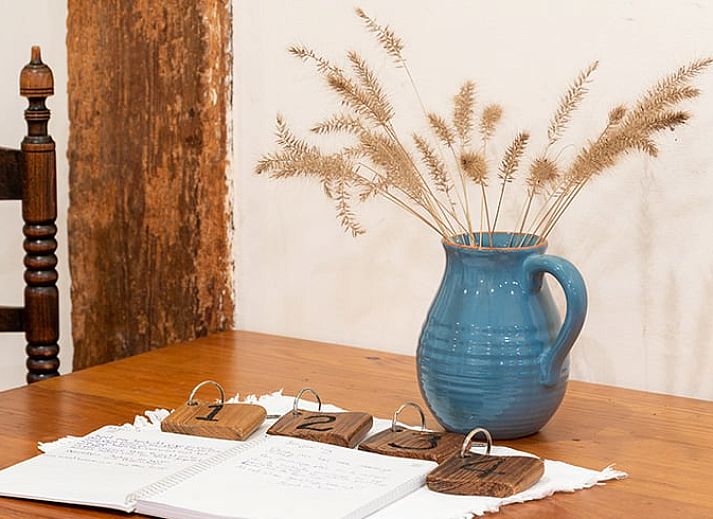 Gemuetliche Essecke im Ferienhaus in Ruinerwold, Suedwest-Drenthe, mit Holzmoebeln und stimmungsvoller Beleuchtung.