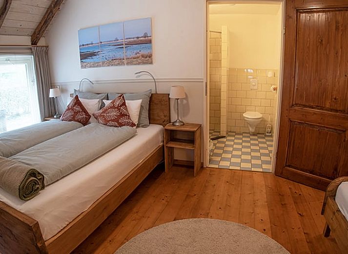 Gemuetliches Esszimmer in Cottage in Ruinerwold, Ferienhaus in Suedwest-Drenthe, mit Holzmoebeln und warmer Beleuchtung.