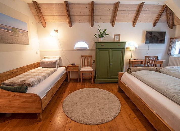 Gemuetliches Esszimmer in Cottage in Ruinerwold, Ferienhaus in Suedwest-Drenthe, mit Holzmoebeln und warmer Beleuchtung.