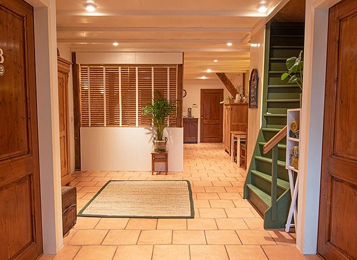 Gemuetliches Esszimmer im Huisje in Ruinerwold, einem Ferienhaus im Suedwesten von Drenthe, mit warmen Holzmoebeln und stimmungsvoller Beleuchtung.