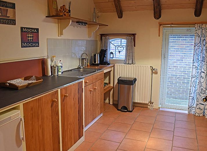 Gemuetliches Esszimmer im Huisje in Ruinerwold, einem Ferienhaus im Suedwesten von Drenthe, mit warmen Holzmoebeln und stimmungsvoller Beleuchtung.