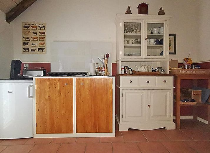 Gemuetliches Esszimmer im Huisje in Ruinerwold, einem Ferienhaus im Suedwesten von Drenthe, mit warmen Holzmoebeln und stimmungsvoller Beleuchtung.