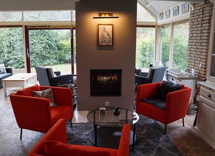 Winterse sfeer bij Vakantiehuis in Zorgvlied, Zuidwest Drenthe, met besneeuwd dak en grote ramen.