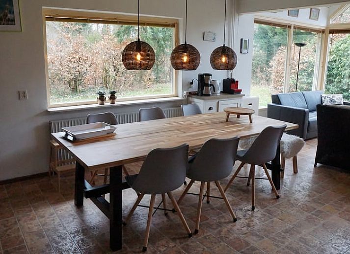 Winterse sfeer bij Vakantiehuis in Zorgvlied, Zuidwest Drenthe, met besneeuwd dak en grote ramen.