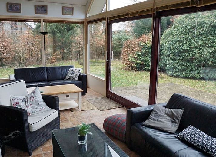 Winterse sfeer bij Vakantiehuis in Zorgvlied, Zuidwest Drenthe, met besneeuwd dak en grote ramen.