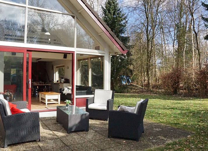 Sneeuw bedekt de tuin van Vakantiehuis in Zorgvlied in Zuidwest Drenthe, met groen en serene stilte.