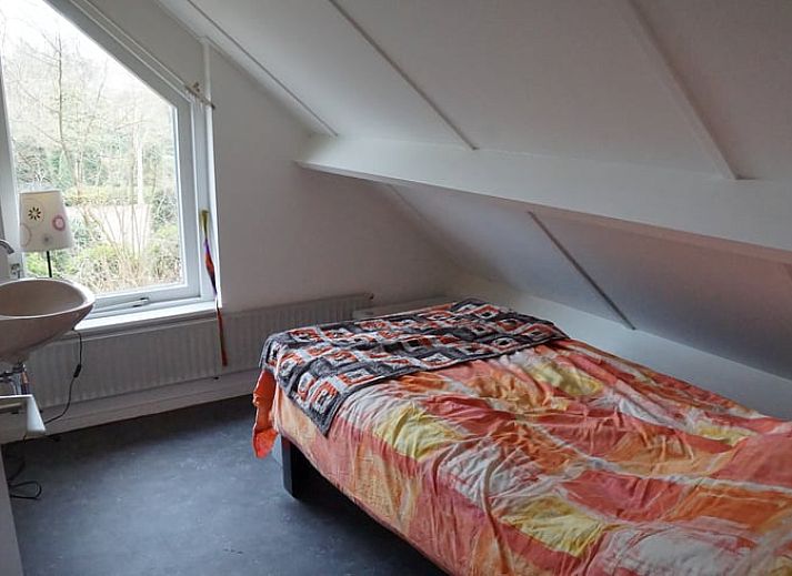 Besneeuwde picknicktafel in de tuin van Vakantiehuis in Zorgvlied, Zuidwest Drenthe, omringd door bomen.