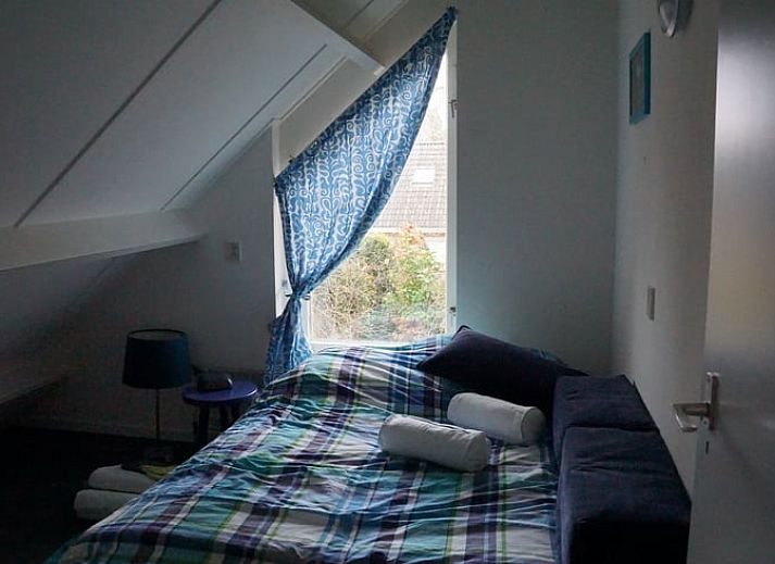 Besneeuwde picknicktafel in de tuin van Vakantiehuis in Zorgvlied, Zuidwest Drenthe, omringd door bomen.