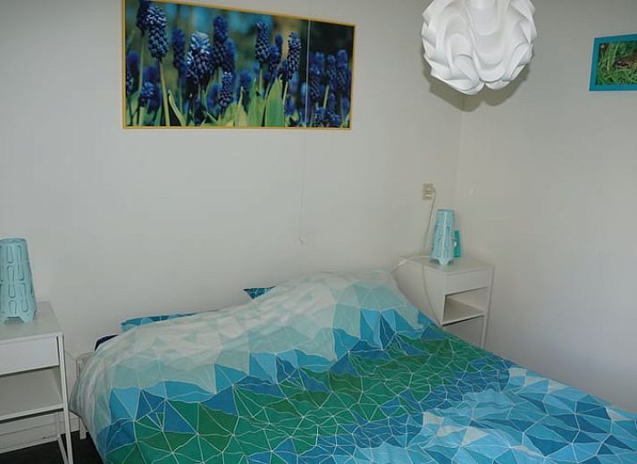 Besneeuwde picknicktafel in de tuin van Vakantiehuis in Zorgvlied, Zuidwest Drenthe, omringd door bomen.