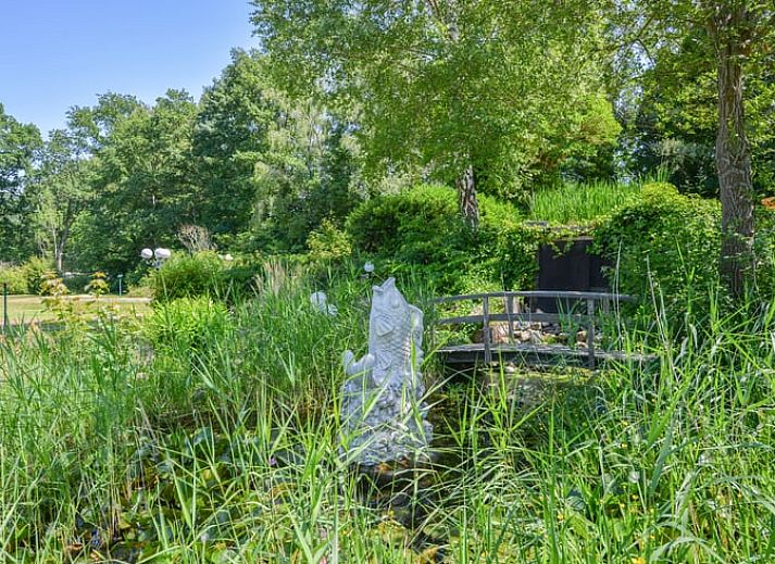 Gemuetliches Wohnzimmer des Ferienhauses in Zorgvlied, Suedwest-Drenthe, mit Blick auf die gruene Natur und moderner Einrichtung.
