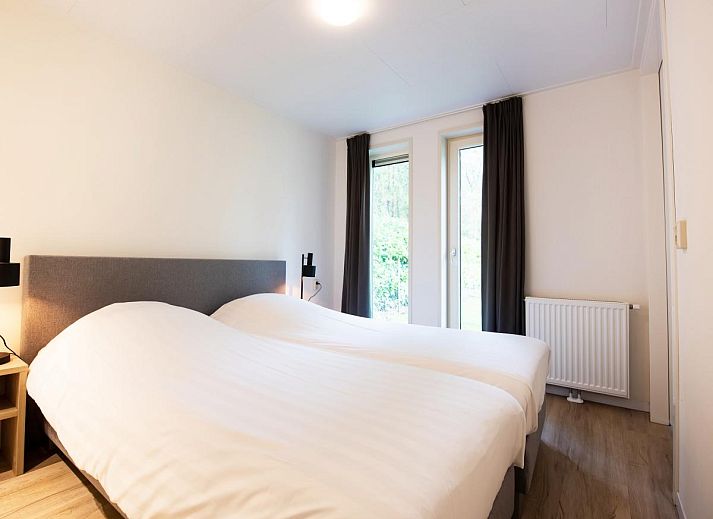 Gezellige woonkamer van chalet De Ganzenpoel in Zorgvlied, Zuidwest Drenthe, met uitzicht op groene natuur en moderne inrichting.