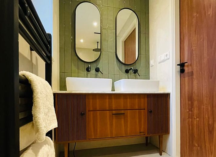 Modern living room of Holiday Home in Zorgvlied, Southwest Drenthe, overlooking green nature through large windows.