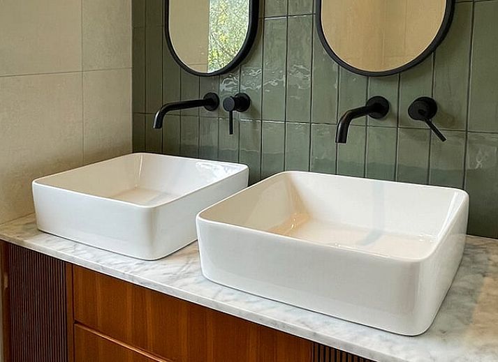 Modern living room of Holiday Home in Zorgvlied, Southwest Drenthe, overlooking green nature through large windows.