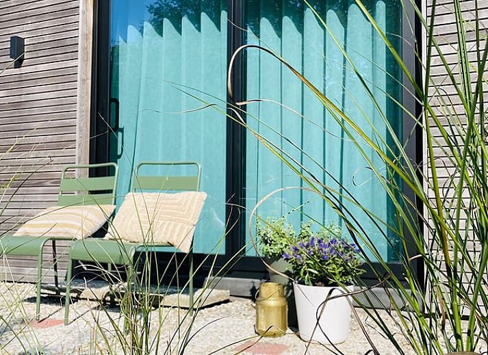 Modern living room of Holiday Home in Zorgvlied, Southwest Drenthe, overlooking green nature through large windows.