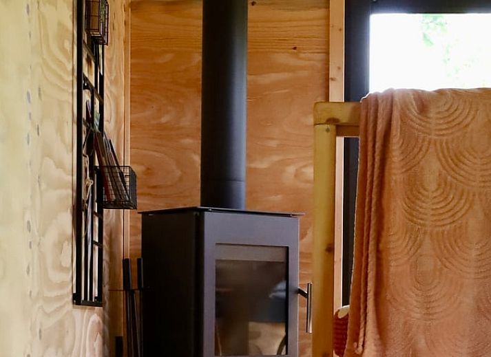 Terrasse des Ferienhauses in Vledder, Drenthe, mit Blick auf den Sonnenuntergang und die gruene Umgebung.