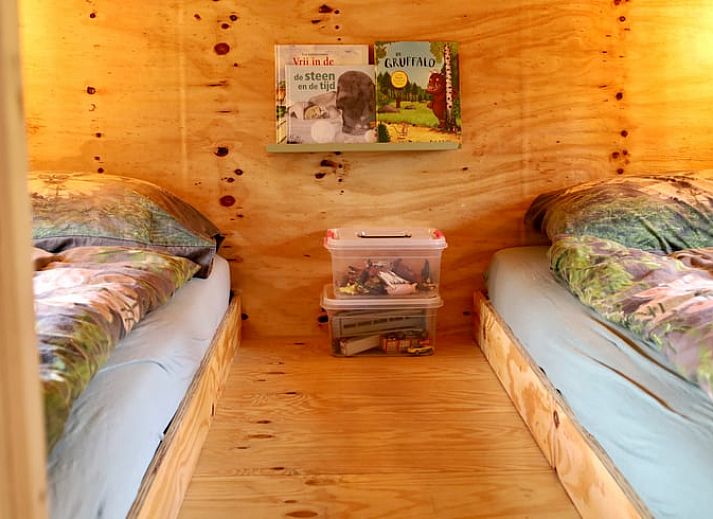 Gemuetliches Interieur des Ferienhauses in Vledder, Drenthe mit bequemen Sitzgelegenheiten und grossem Fenster.