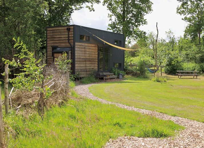 Gemuetliches Interieur des Ferienhauses in Vledder, Drenthe mit bequemen Sitzgelegenheiten und grossem Fenster.