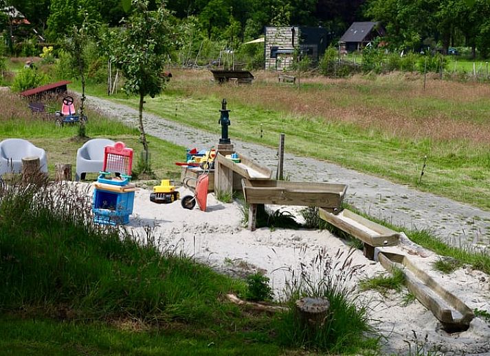 Gemuetliches Wohnzimmer des Ferienhauses in Vledder, Suedwest-Drenthe, mit Holzofen und Waldblick.