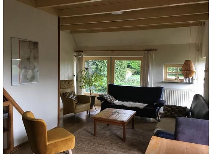 Gezellige eetruimte in Vakantiehuisje in Wapse, Drenthe, met lange houten tafel en moderne keuken.