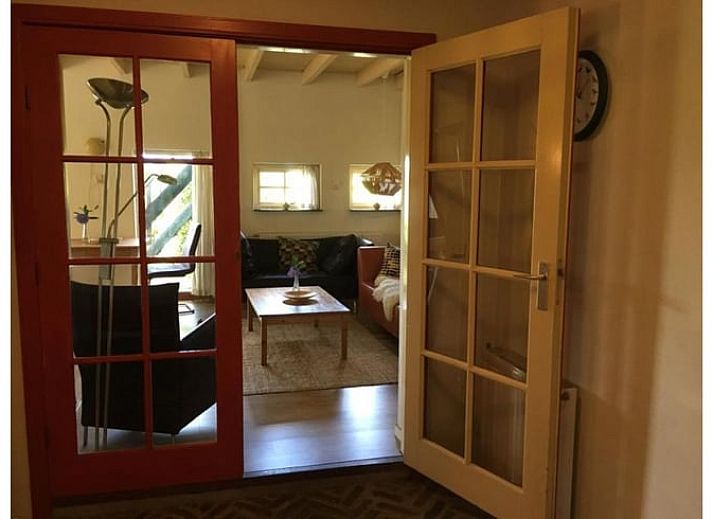 Gezellige eetruimte in Vakantiehuisje in Wapse, Drenthe, met lange houten tafel en moderne keuken.