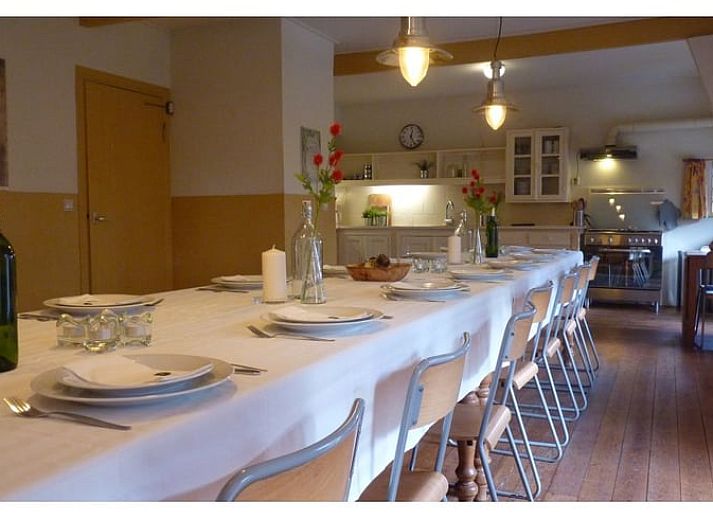 Gezellige eetruimte in Vakantiehuisje in Wapse, Drenthe, met lange houten tafel en moderne keuken.