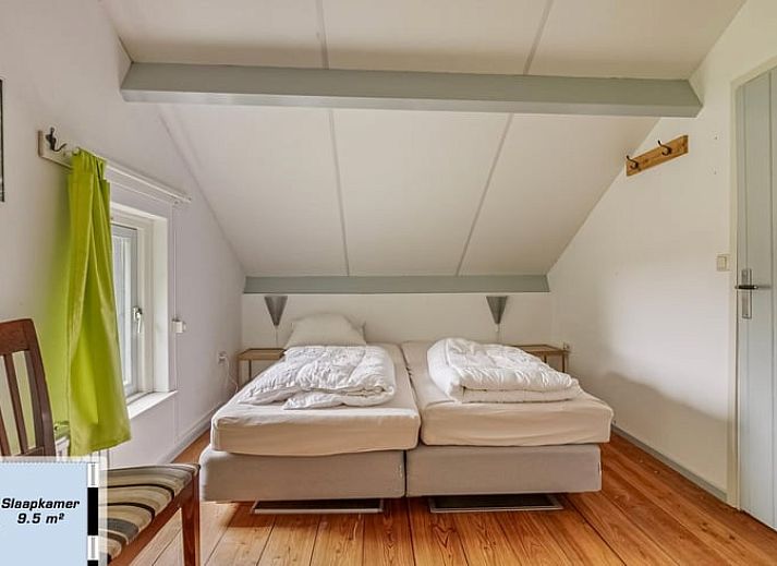 Gezellige woonkamer van Vakantiehuisje in Wapse, Zuidwest Drenthe, met houten balken en comfortabele zithoek voor een ontspannen verblijf.