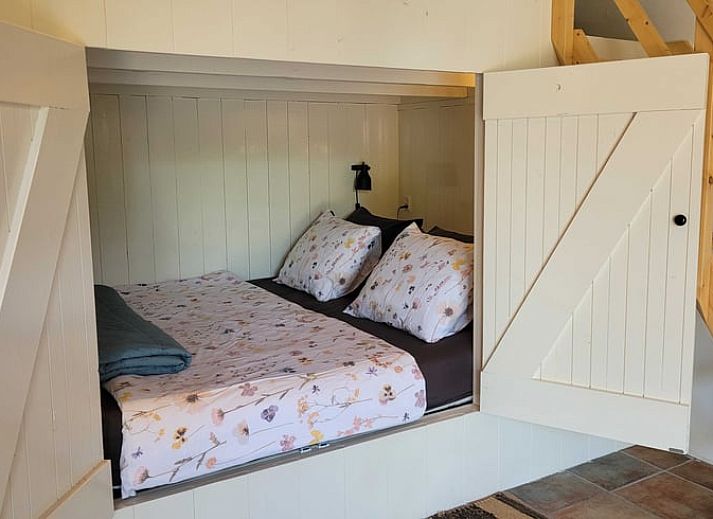 Gemuetliche Veranda am Ferienhaus in Wateren, Westerveld, Suedwest-Drenthe, mit Blumen und Sitzgelegenheiten.