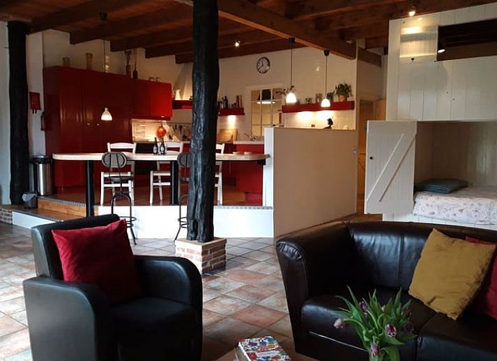 Gemuetliche Veranda am Ferienhaus in Wateren, Westerveld, Suedwest-Drenthe, mit Blumen und Sitzgelegenheiten.